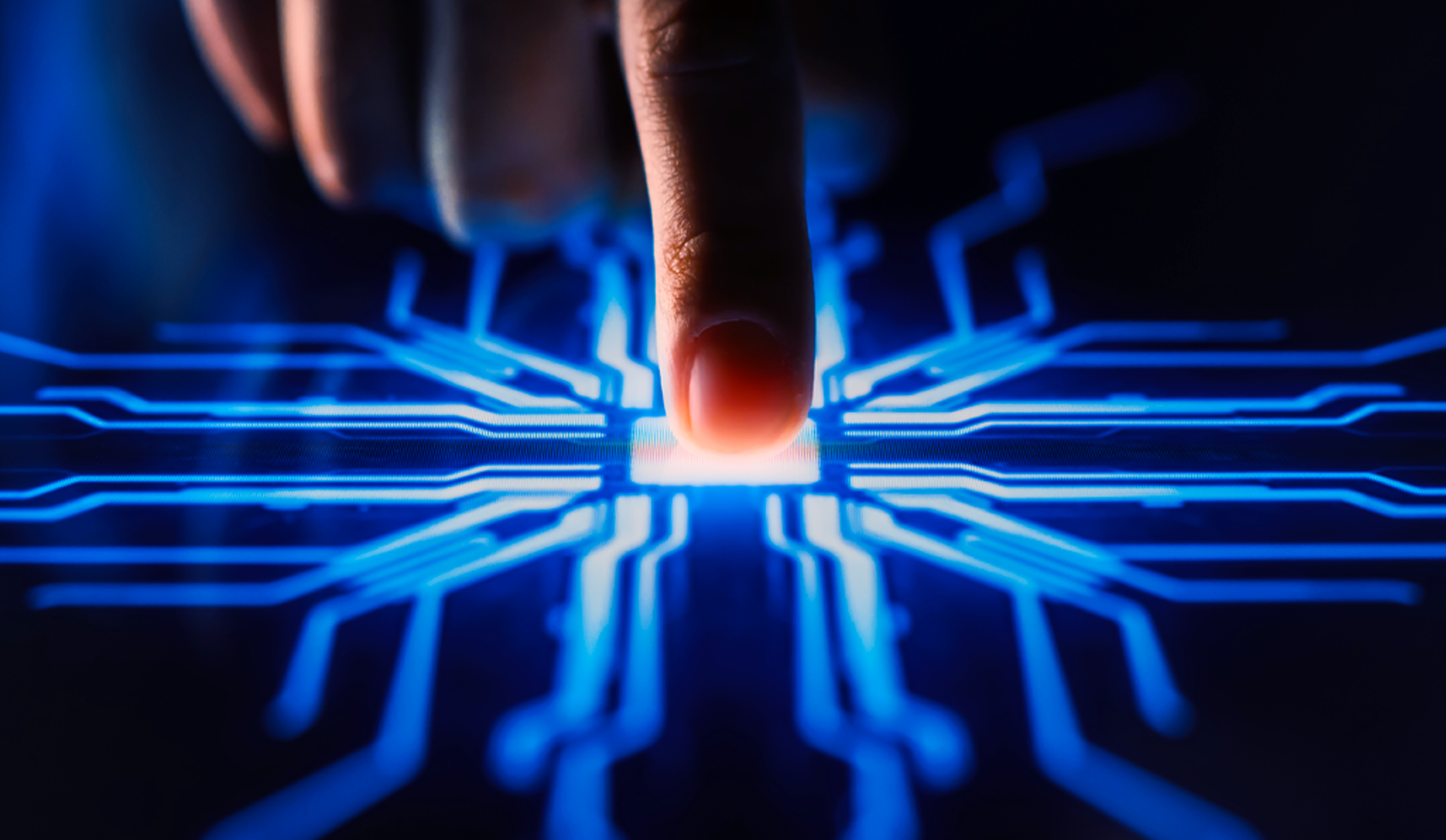 A close-up of a hand activating a button on a circuit board, showcasing the connection between human and technology.